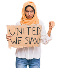 Sticker - Young brunette arab woman holding united we stand banner annoyed and frustrated shouting with anger, yelling crazy with anger and hand raised