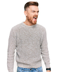 Wall Mural - Young redhead man wearing casual winter sweater angry and mad screaming frustrated and furious, shouting with anger. rage and aggressive concept.