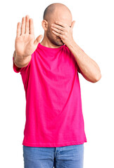 Sticker - Young handsome man wearing casual t shirt covering eyes with hands and doing stop gesture with sad and fear expression. embarrassed and negative concept.