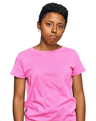 Wall Mural - Young african american woman wearing casual clothes looking sleepy and tired, exhausted for fatigue and hangover, lazy eyes in the morning.