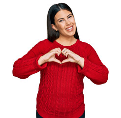 Canvas Print - Beautiful brunette woman wearing casual sweater smiling in love showing heart symbol and shape with hands. romantic concept.