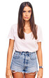 © Krakenimages.com - Young hispanic woman wearing casual white tshirt skeptic and nervous, frowning upset because of problem. negative person.