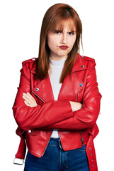 Poster - Redhead young woman wearing red leather jacket skeptic and nervous, disapproving expression on face with crossed arms. negative person.