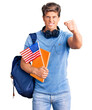 © Krakenimages.com - Young handsome man wearing student backpack and headphones holding book and america flag annoyed and frustrated shouting with anger, yelling crazy with anger and hand raised