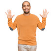 © Krakenimages.com - Hispanic adult man wearing casual winter sweater showing and pointing up with fingers number ten while smiling confident and happy.