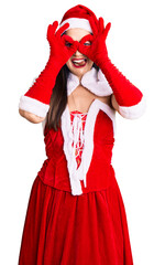 Sticker - Young beautiful caucasian woman wearing santa claus costume doing ok gesture like binoculars sticking tongue out, eyes looking through fingers. crazy expression.