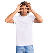 © Krakenimages.com - Young hispanic man wearing casual white tshirt trying to open eyes with fingers, sleepy and tired for morning fatigue
