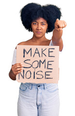 Wall Mural - Young african american girl holding make some noise banner pointing with finger to the camera and to you, confident gesture looking serious