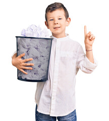 Sticker - Cute blond kid holding paper bin full of crumpled papers surprised with an idea or question pointing finger with happy face, number one