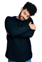 Poster - Young arab man with beard wearing casual winter sweater hugging oneself happy and positive, smiling confident. self love and self care