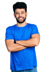 Sticker - Young arab man with beard wearing casual blue t shirt happy face smiling with crossed arms looking at the camera. positive person.