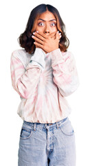 Wall Mural - Young beautiful mixed race woman wearing casual tie dye sweatshirt shocked covering mouth with hands for mistake. secret concept.