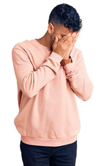 Wall Mural - Young hispanic man wearing casual clothes with sad expression covering face with hands while crying. depression concept.