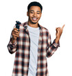 © Krakenimages.com - Young african american man holding electric razor machine smiling happy pointing with hand and finger to the side