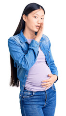 Sticker - Young beautiful chinese woman pregnant expecting baby hand on mouth telling secret rumor, whispering malicious talk conversation