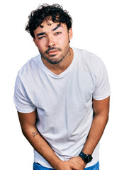 Canvas Print - Hispanic young man with beard wearing casual white t shirt skeptic and nervous, frowning upset because of problem. negative person.