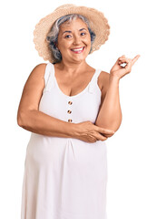 Poster - Senior woman with gray hair wearing summer hat and summer clothes smiling happy pointing with hand and finger to the side