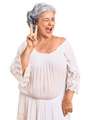 Poster - Senior woman with gray hair wearing bohemian style smiling with happy face winking at the camera doing victory sign with fingers. number two.