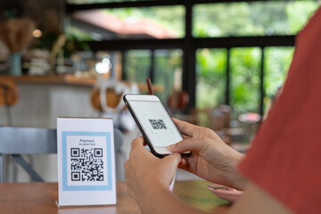Woman use smartphone to scan QR code for order menu in cafe restaurant with a digital delivery. Choose menu and order accumulate discount. E wallet, technology, pay online, credit card, bank app.