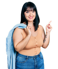 Canvas Print - Young hispanic plus size woman wearing holding denim jacket smiling happy pointing with hand and finger to the side