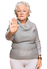 Wall Mural - Senior grey-haired woman wearing casual winter sweater doing stop sing with palm of the hand. warning expression with negative and serious gesture on the face.