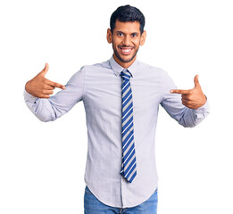 Sticker - Young latin man wearing business clothes looking confident with smile on face, pointing oneself with fingers proud and happy.