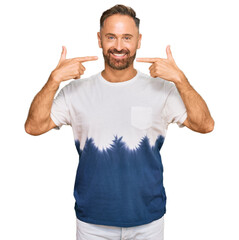 Sticker - Handsome middle age man wearing casual tie dye tshirt smiling cheerful showing and pointing with fingers teeth and mouth. dental health concept.