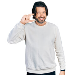 Wall Mural - Middle age caucasian man wearing casual clothes smiling and confident gesturing with hand doing small size sign with fingers looking and the camera. measure concept.