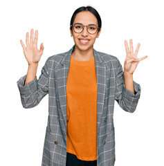 Wall Mural - Young hispanic girl wearing business jacket and glasses showing and pointing up with fingers number nine while smiling confident and happy.