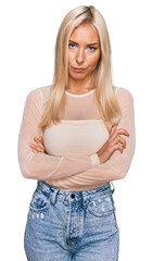 Canvas Print - Young blonde woman wearing casual clothes skeptic and nervous, disapproving expression on face with crossed arms. negative person.