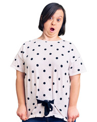 Wall Mural - Brunette woman with down syndrome wearing casual clothes afraid and shocked with surprise expression, fear and excited face.