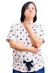 Poster - Brunette woman with down syndrome wearing casual clothes with hand on chin thinking about question, pensive expression. smiling with thoughtful face. doubt concept.