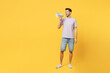 Young smiling man he wears light purple t-shirt casual clothes hold in hand megaphone scream announces discounts sale Hurry up isolated on plain yellow background studio portrait. Lifestyle concept.