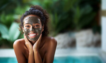 Dark Skinned Woman Stands Topless Cares About Face Skin Applies Nourishing Clay Mask For Rejuvenation Does Anti Wrinkle Procedures Isolated Over Green Background. Beauty Concept Copy Space