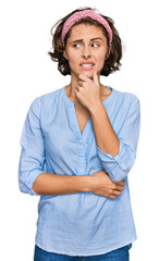 Sticker - Young hispanic woman wearing casual clothes serious face thinking about question with hand on chin, thoughtful about confusing idea