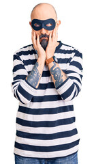 Wall Mural - Young handsome man wearing burglar mask tired hands covering face, depression and sadness, upset and irritated for problem