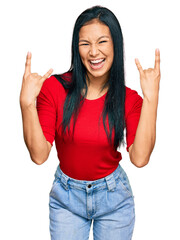 Canvas Print - Beautiful hispanic woman wearing casual clothes shouting with crazy expression doing rock symbol with hands up. music star. heavy concept.