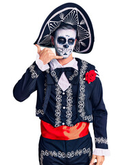 Wall Mural - Young man wearing day of the dead costume over background smiling doing phone gesture with hand and fingers like talking on the telephone. communicating concepts.