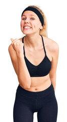 Wall Mural - Young beautiful blonde woman wearing sportswear angry and mad raising fist frustrated and furious while shouting with anger. rage and aggressive concept.