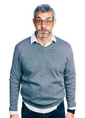 Poster - Middle age hispanic with grey hair wearing glasses puffing cheeks with funny face. mouth inflated with air, crazy expression.