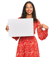 Sticker - Young african american girl holding blank empty banner smiling happy pointing with hand and finger