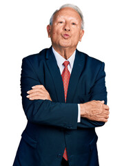 Canvas Print - Senior business man with grey hair with arms crossed gesture looking at the camera blowing a kiss being lovely and sexy. love expression.