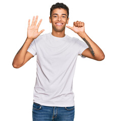 Sticker - Young handsome african american man wearing casual white tshirt showing and pointing up with fingers number six while smiling confident and happy.