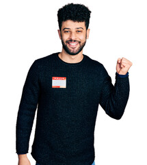 Poster - Young arab man with beard wearing hello my name is sticker identification screaming proud, celebrating victory and success very excited with raised arm