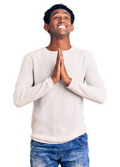 Wall Mural - African handsome man wearing casual winter sweater begging and praying with hands together with hope expression on face very emotional and worried. begging.