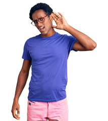 Wall Mural - African handsome man wearing casual clothes and glasses smiling with hand over ear listening an hearing to rumor or gossip. deafness concept.