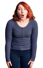 Poster - Young beautiful redhead woman wearing casual t-shirt scared and amazed with open mouth for surprise, disbelief face