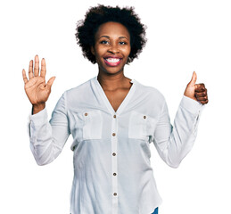 Canvas Print - African american woman with afro hair wearing casual white t shirt showing and pointing up with fingers number six while smiling confident and happy.