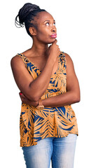 Canvas Print - Young african american woman wearing casual clothes with hand on chin thinking about question, pensive expression. smiling with thoughtful face. doubt concept.