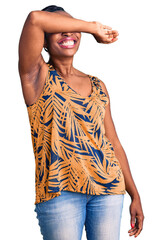 Poster - Young african american woman wearing casual clothes covering eyes with arm smiling cheerful and funny. blind concept.